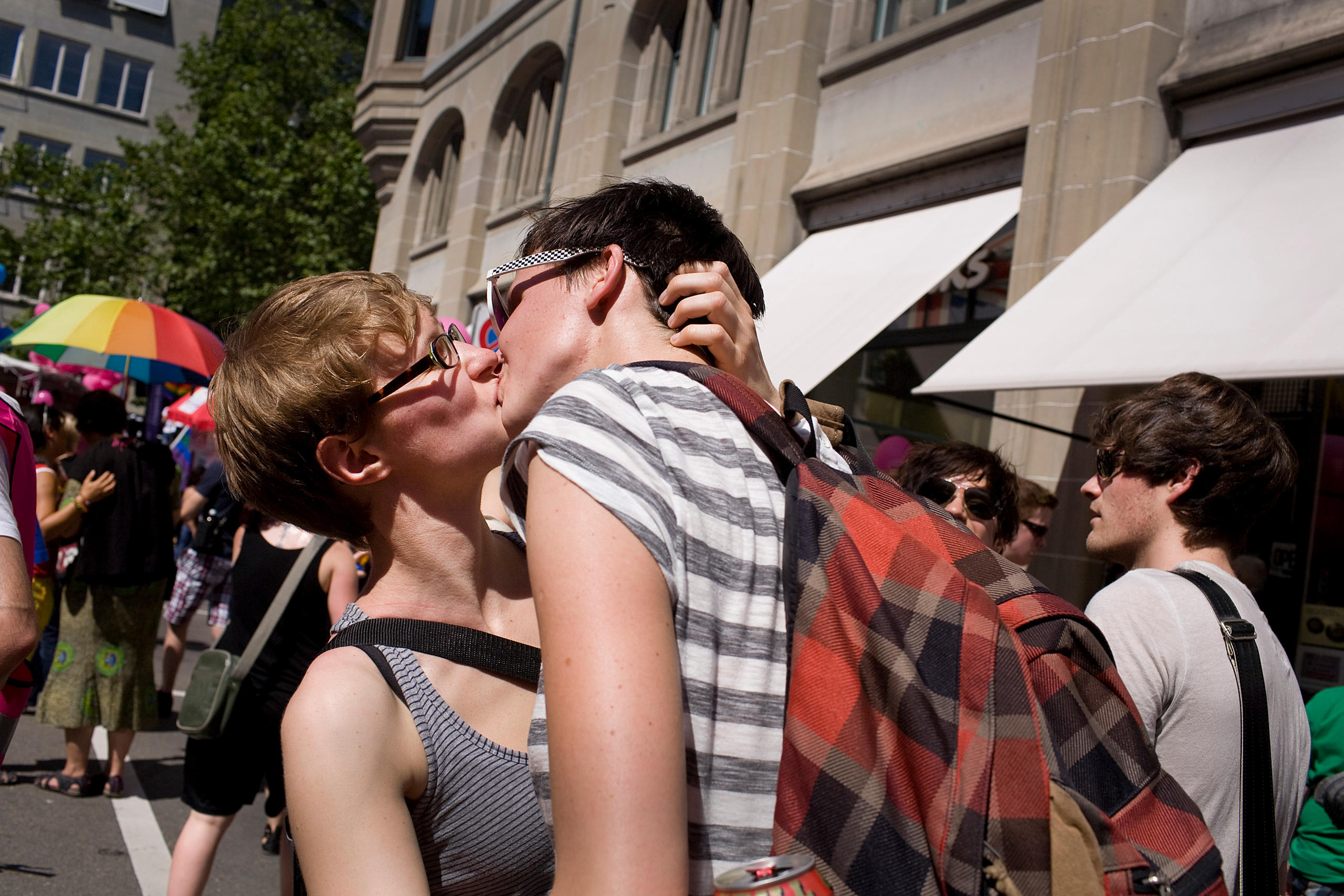 Two women kiss in a crowded street