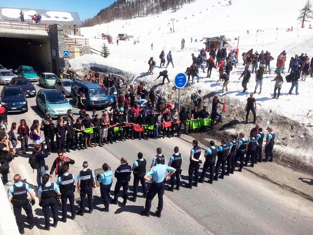 Cordone di manifestanti e agenti della polizia sulla strada.