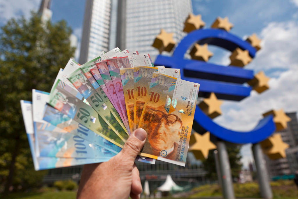 Swiss francs in front of the Euro sign of the European Central Bank