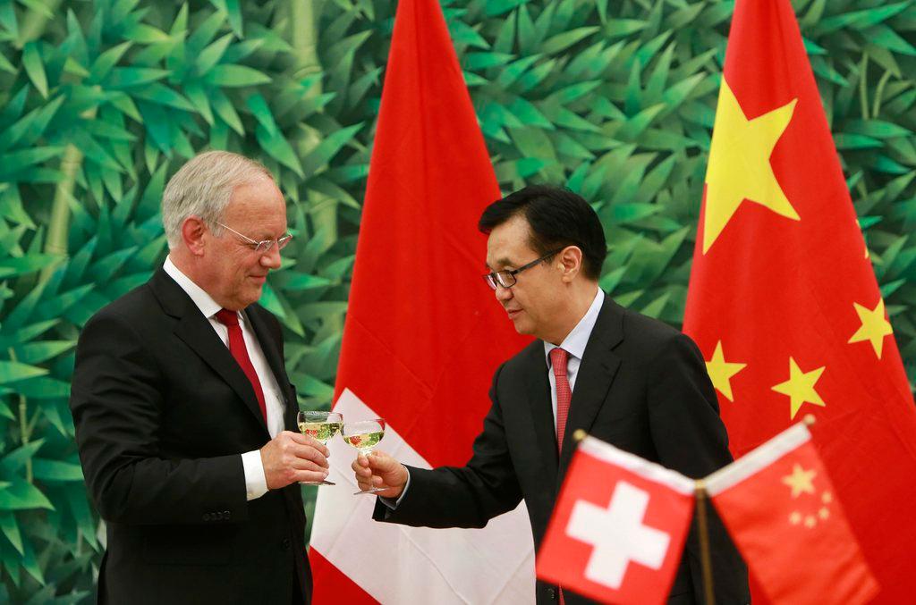 Swiss Economics Minister Johann Schneider-Ammann and Chinese Commerce Minister Gao Hucheng toast the deal in 2013.