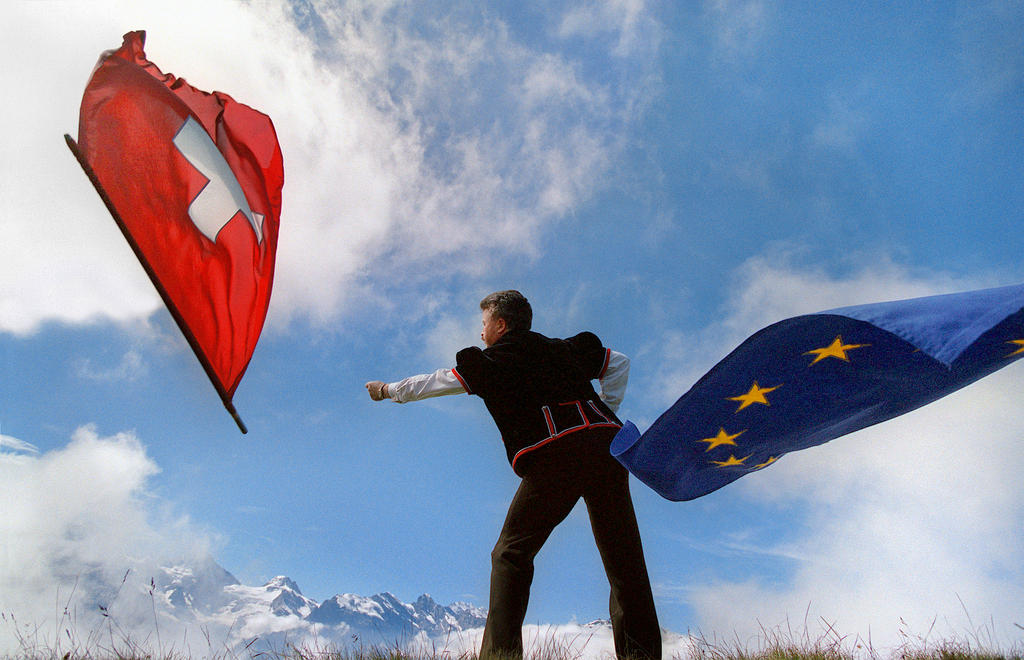Ein Fahnenschwinger schiesst die Schweizer Fahne in den blauen Himmel.