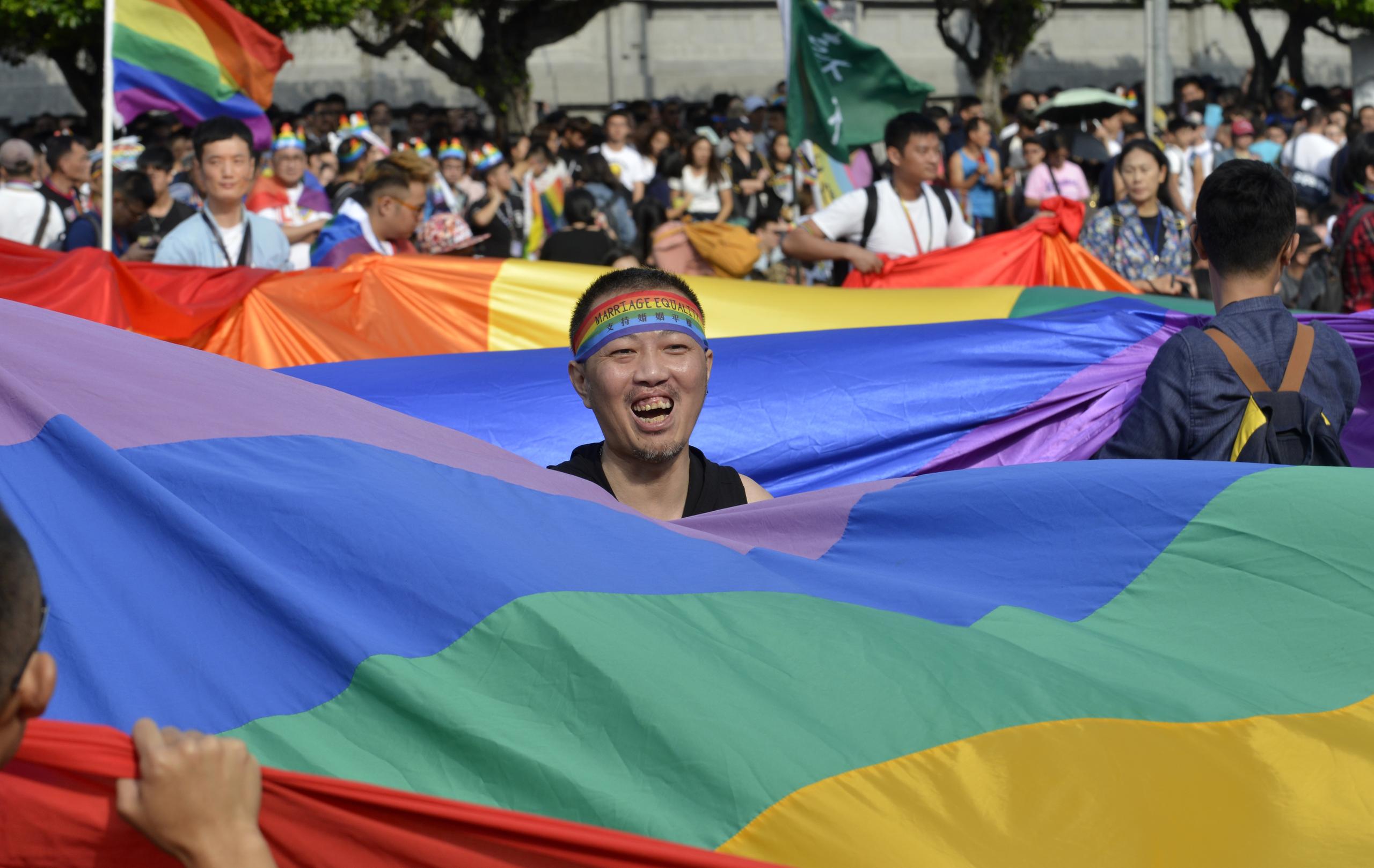 أحد النشطاء في تايوان يحمل علم قوس قزح أثناء تظاهرة للمثليين في تايوان