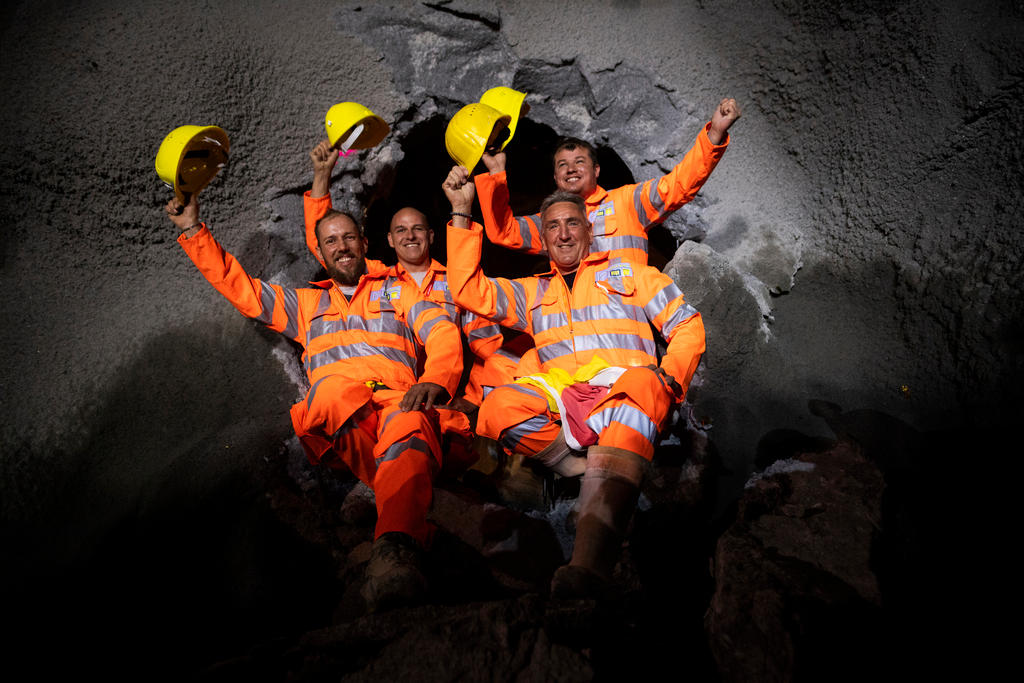 Miners pose in front of tunnel hole