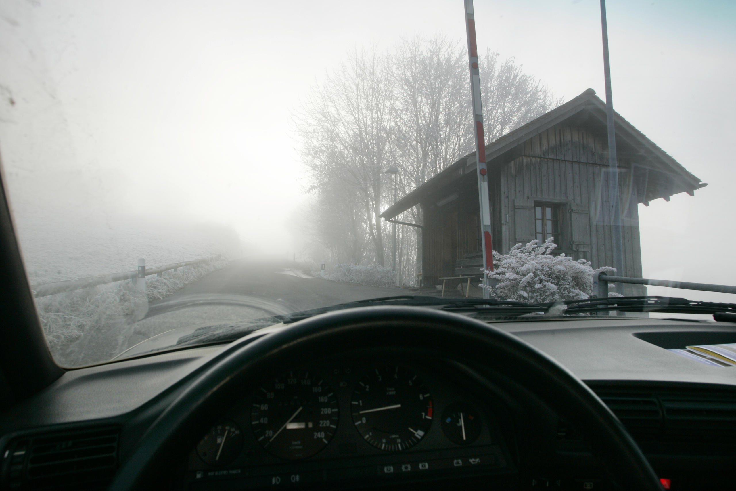 Schlagbaum und Grenzhäuschen im Nebel