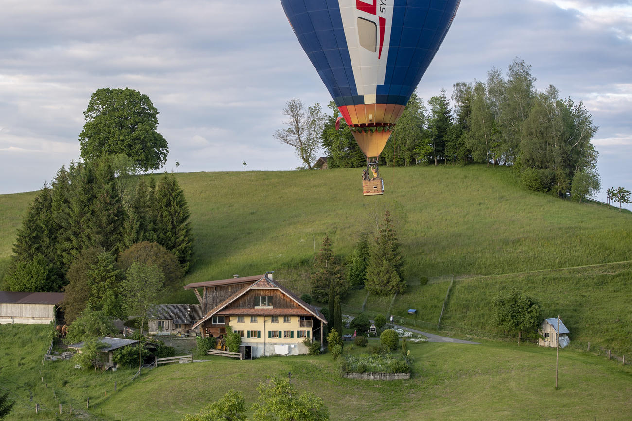 синий воздушный шар над зеленой травой и деревней