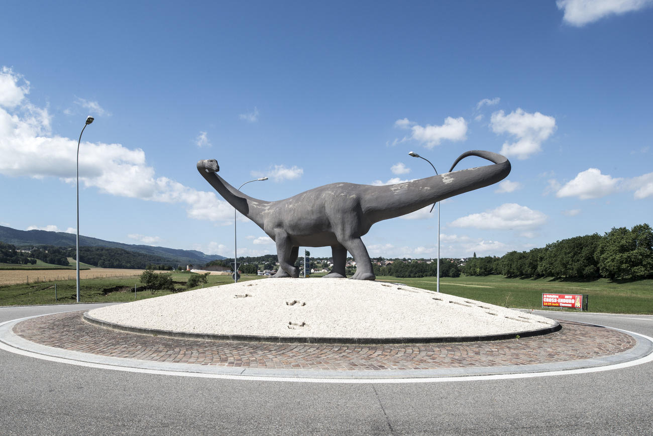 A sculptered dinosaur on a traffic circle near Porrentruy