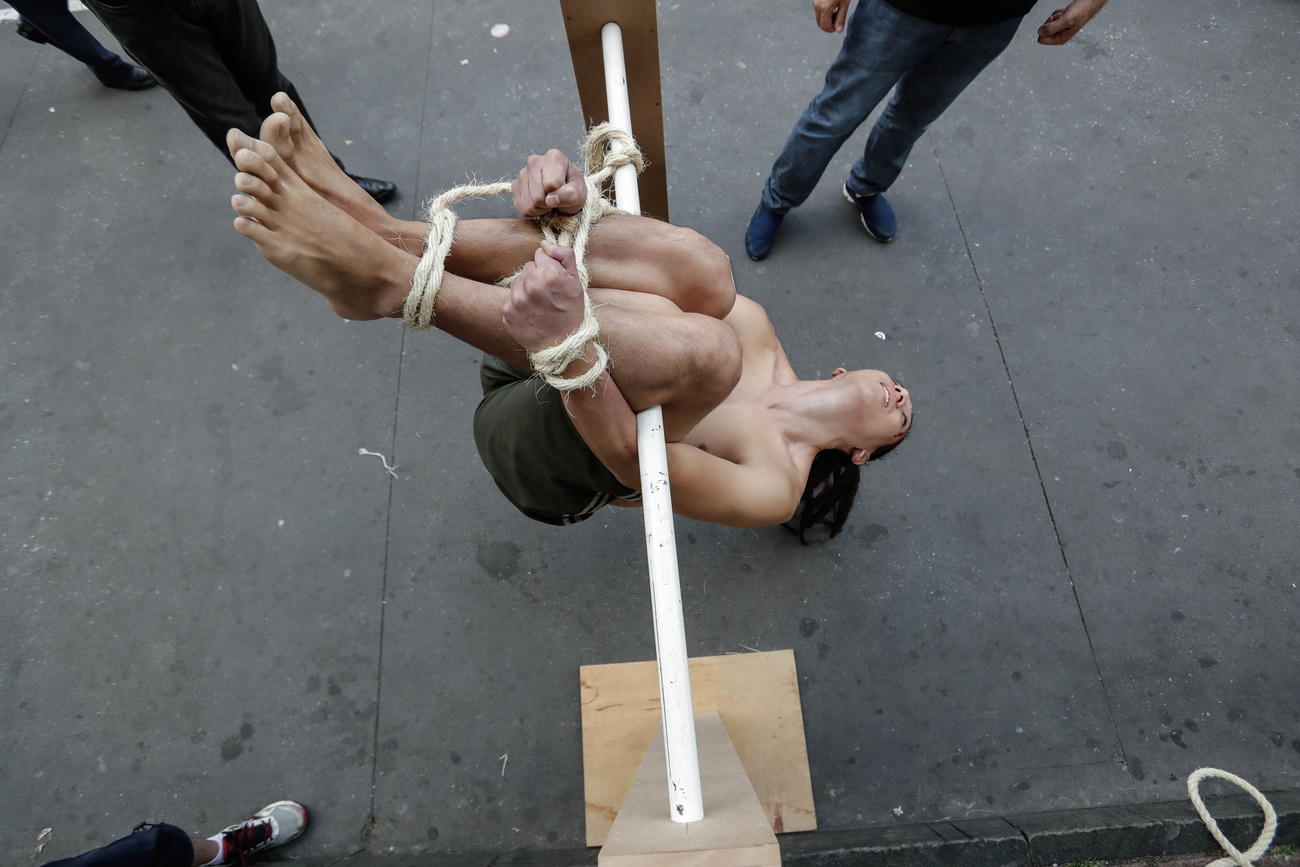 Voluntário demonstra um método de tortura conhecido como  Pau de Arara