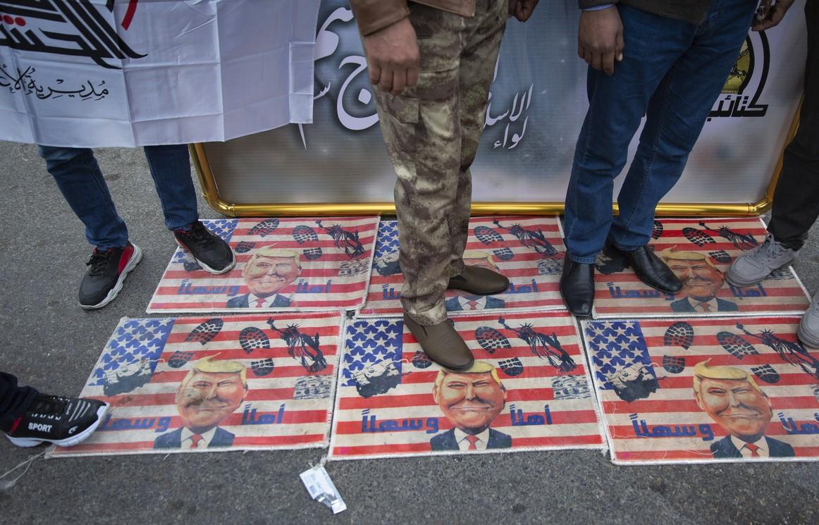 أقدام رجال فوق أعلام أمريكية ملقاة على الأرض