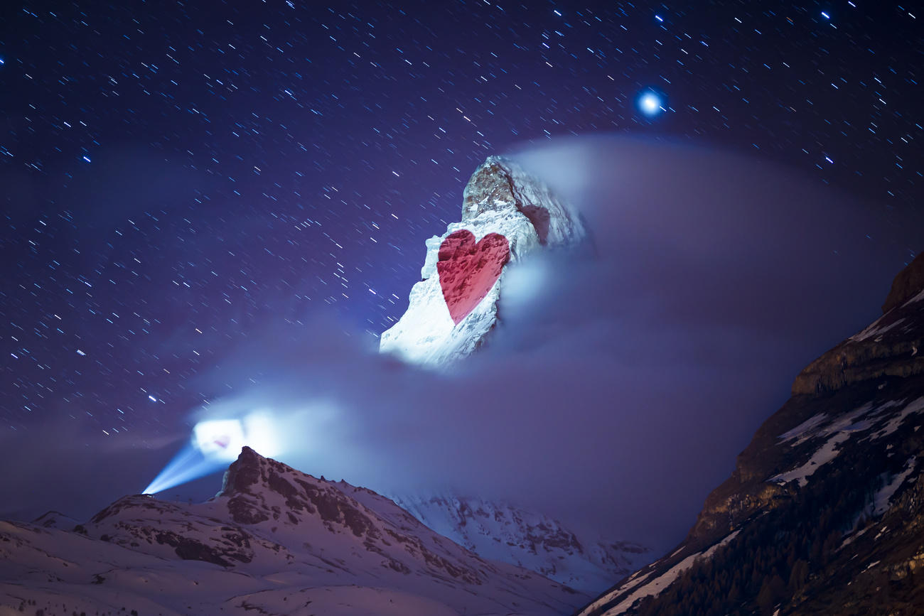 صورة لقلب أحمر تم إسقاطها على جبل تكسوه الثلوج