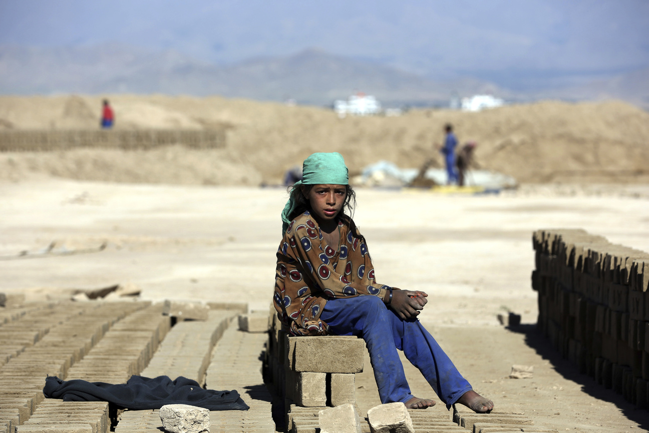 Amina, 9 years old, poses for a photograph as she works at a local brick factory on the outskirts of Kabul, Afghanistan.