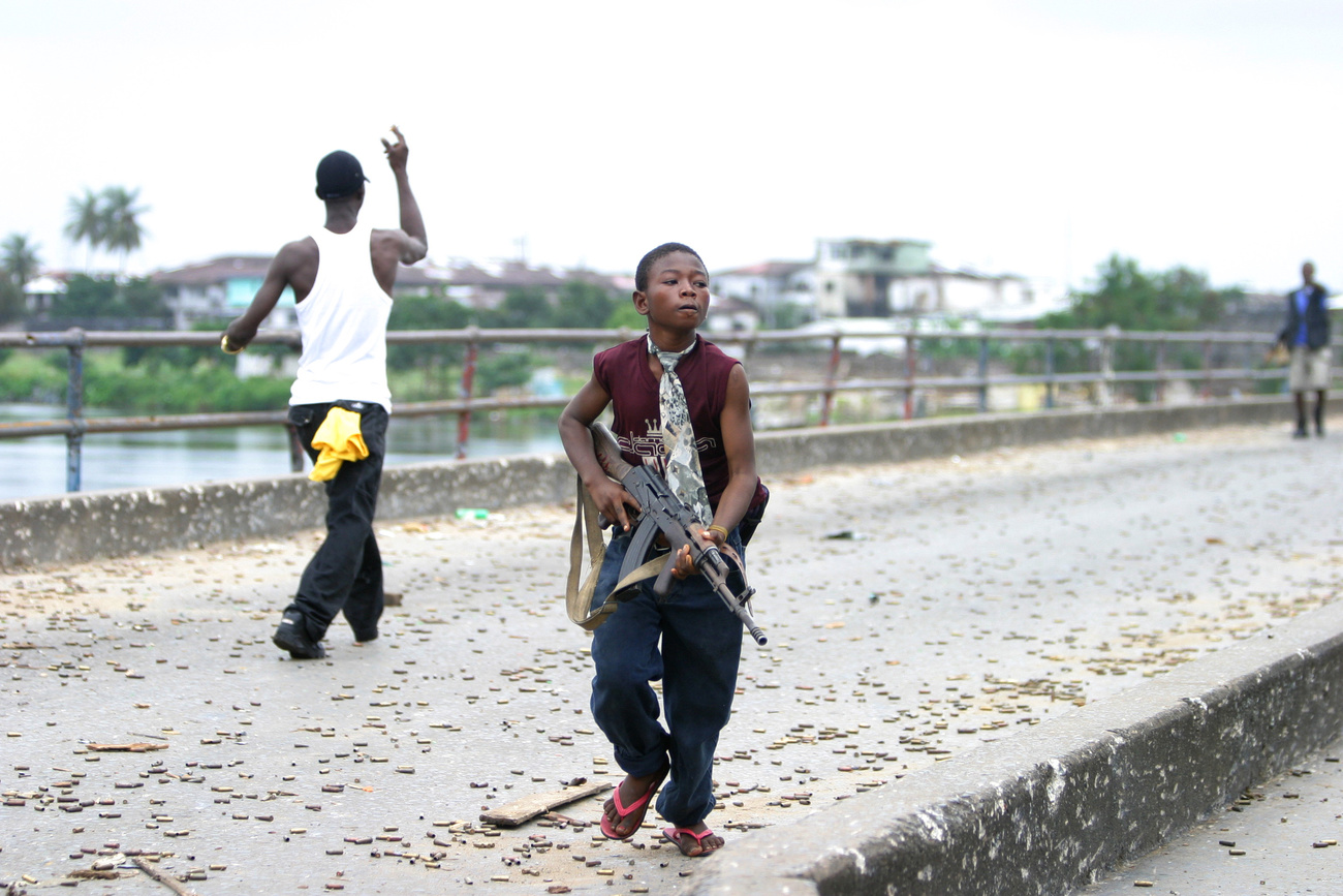 طفل جندي في ليبيريا يحمل رشاشا