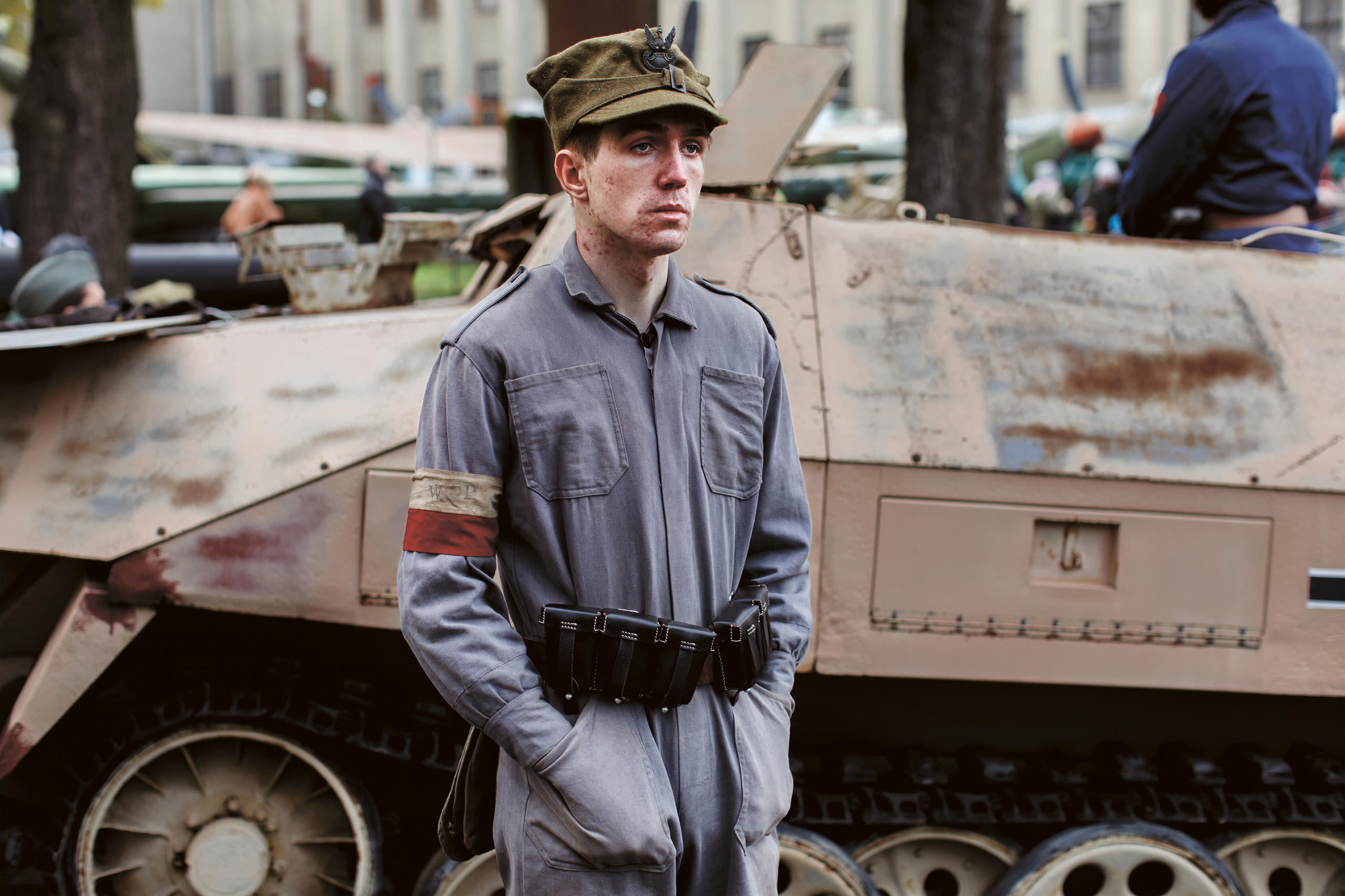 Junger Mann in Uniform vor Panzer