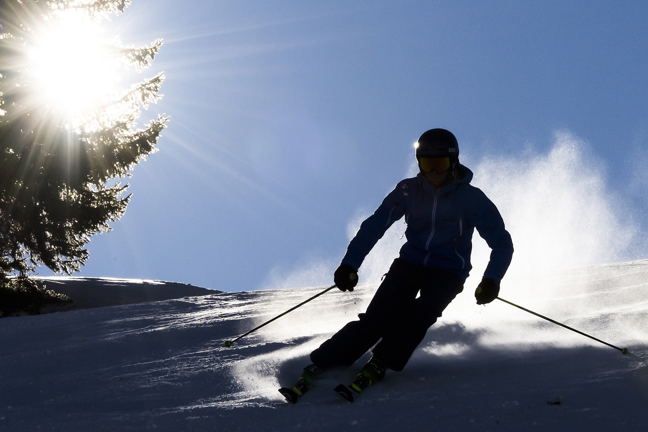 Skier on slope with snow blowing up.