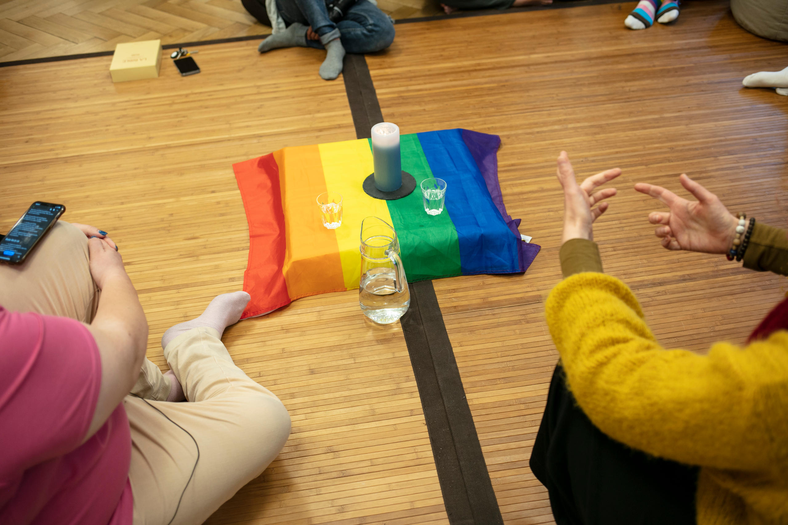 personas reunidas con una bandera gay en medio