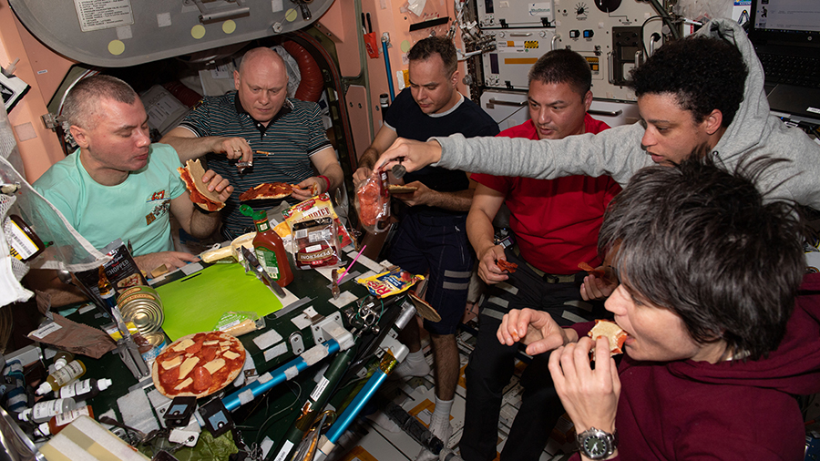 Crew der Internationalen Raumstation (ISS) isst gemeinsam eine Pizza
