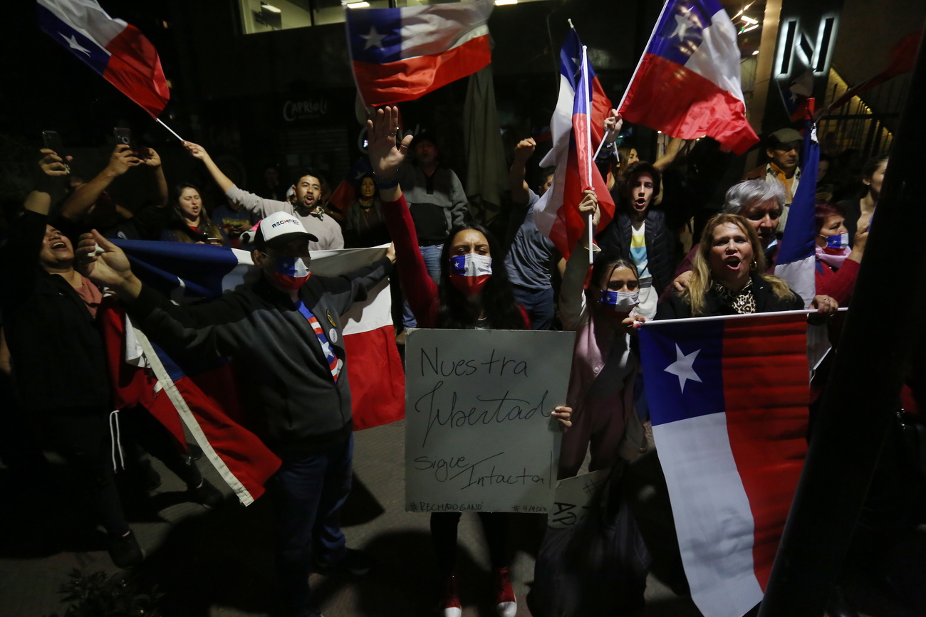 pessoas nas ruas com bandeiras chilenas