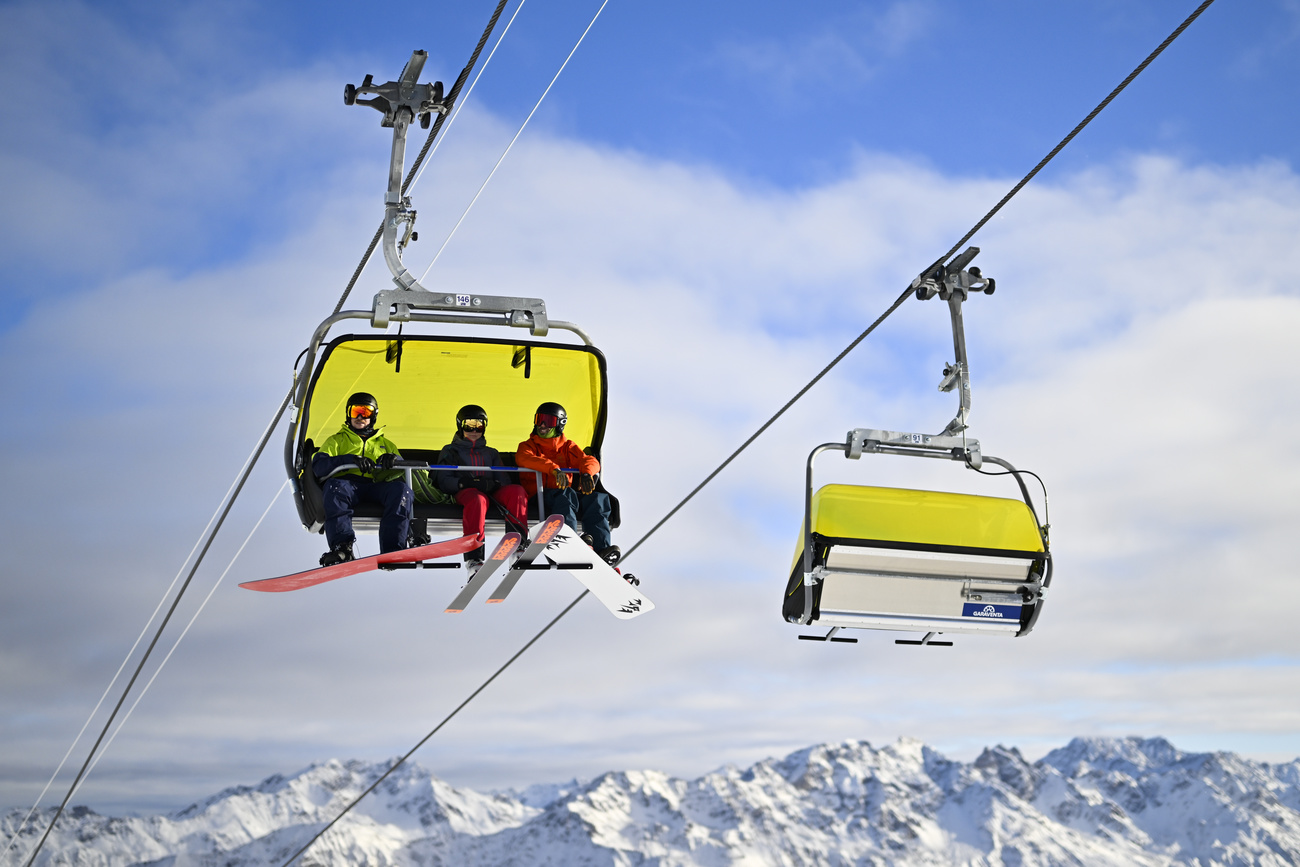 ثلاثة متزلجين يركبون مصعد تزلج