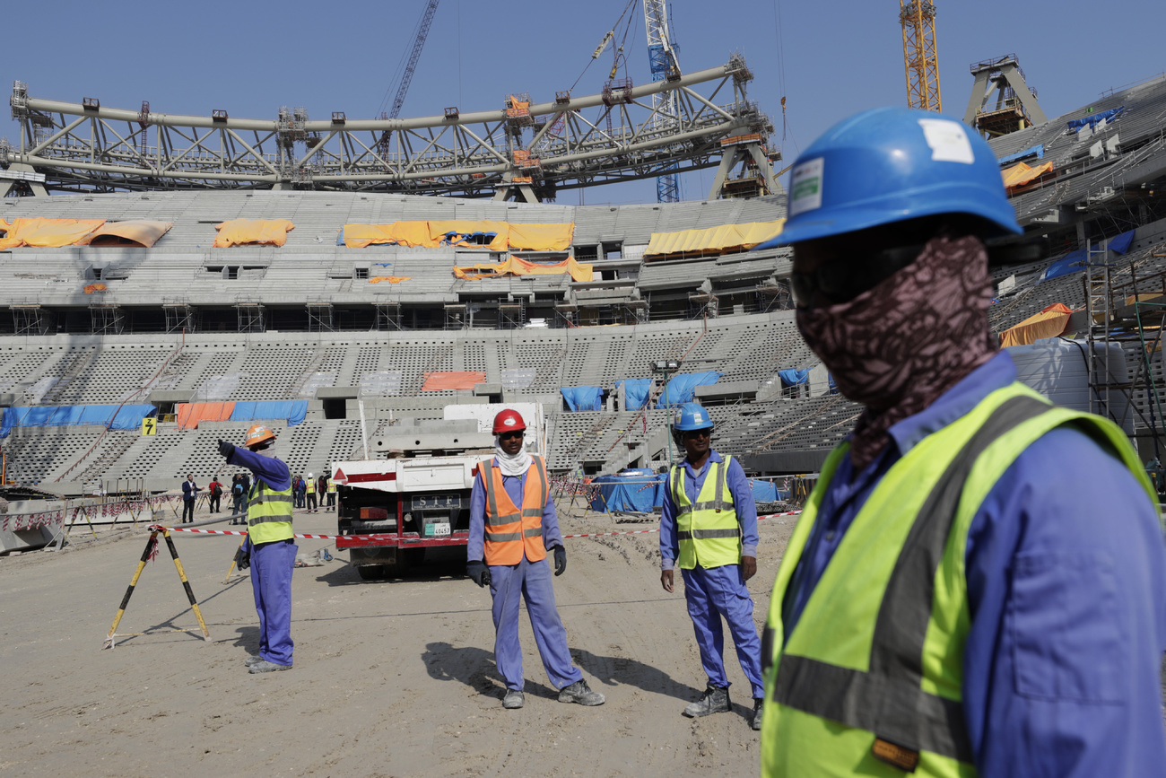 Trabalhadores construindo um estádio de futebol no Qatar