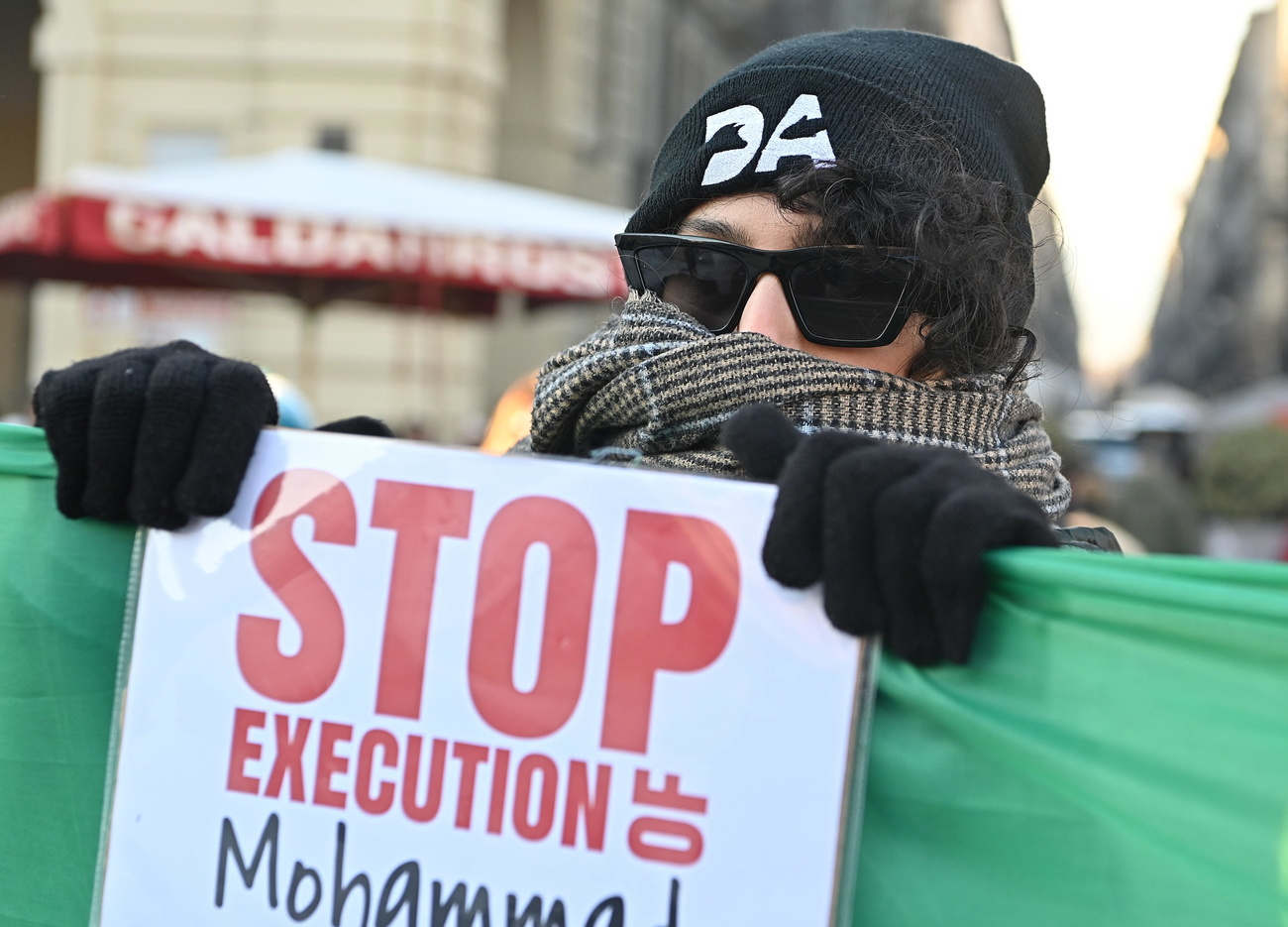 شخص في إيطاليا يحمل لافتة تطالب إيران بوقف عمليات الإعدام