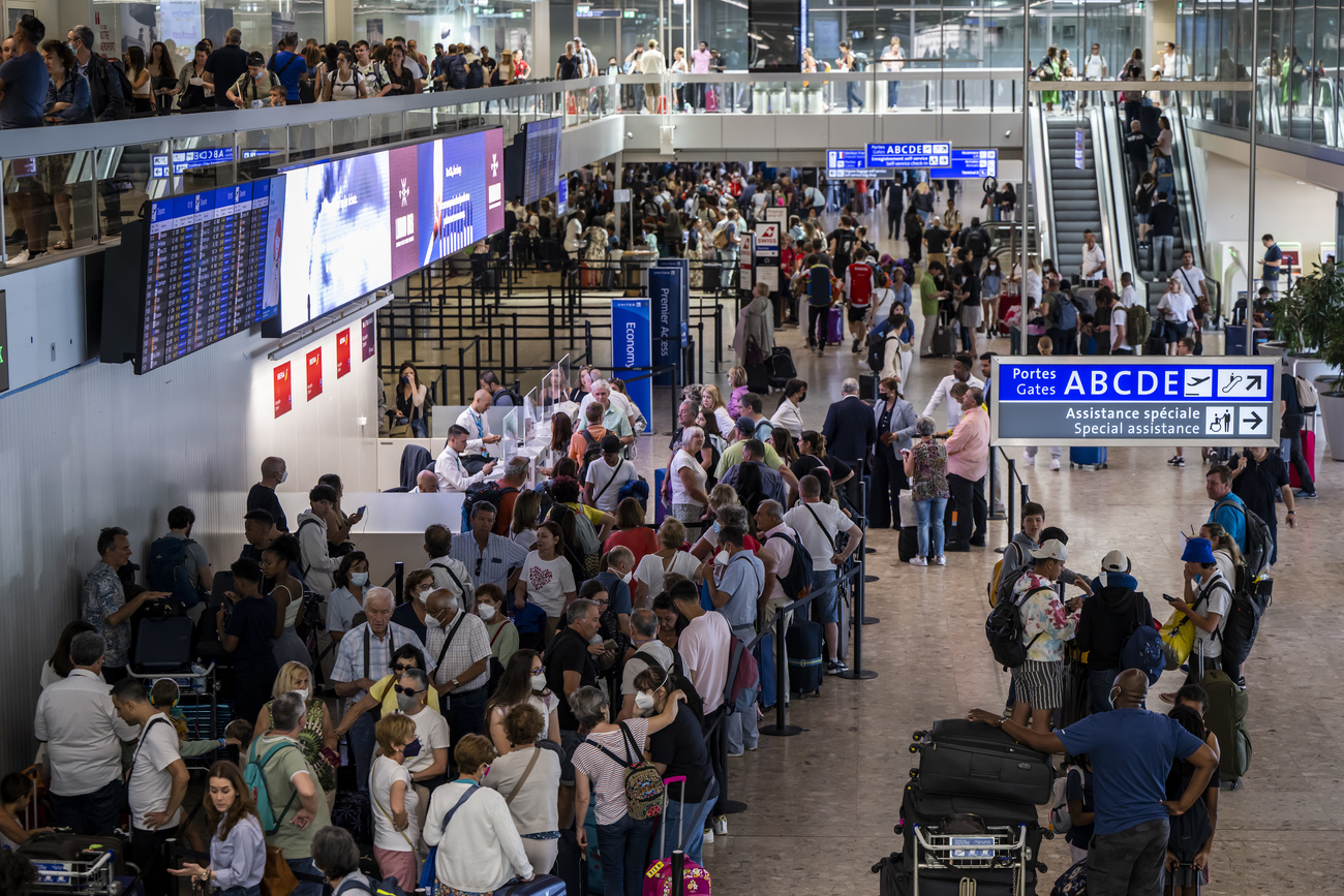 أشخاص يقفون في صفوف متعددة في مطار جنيف