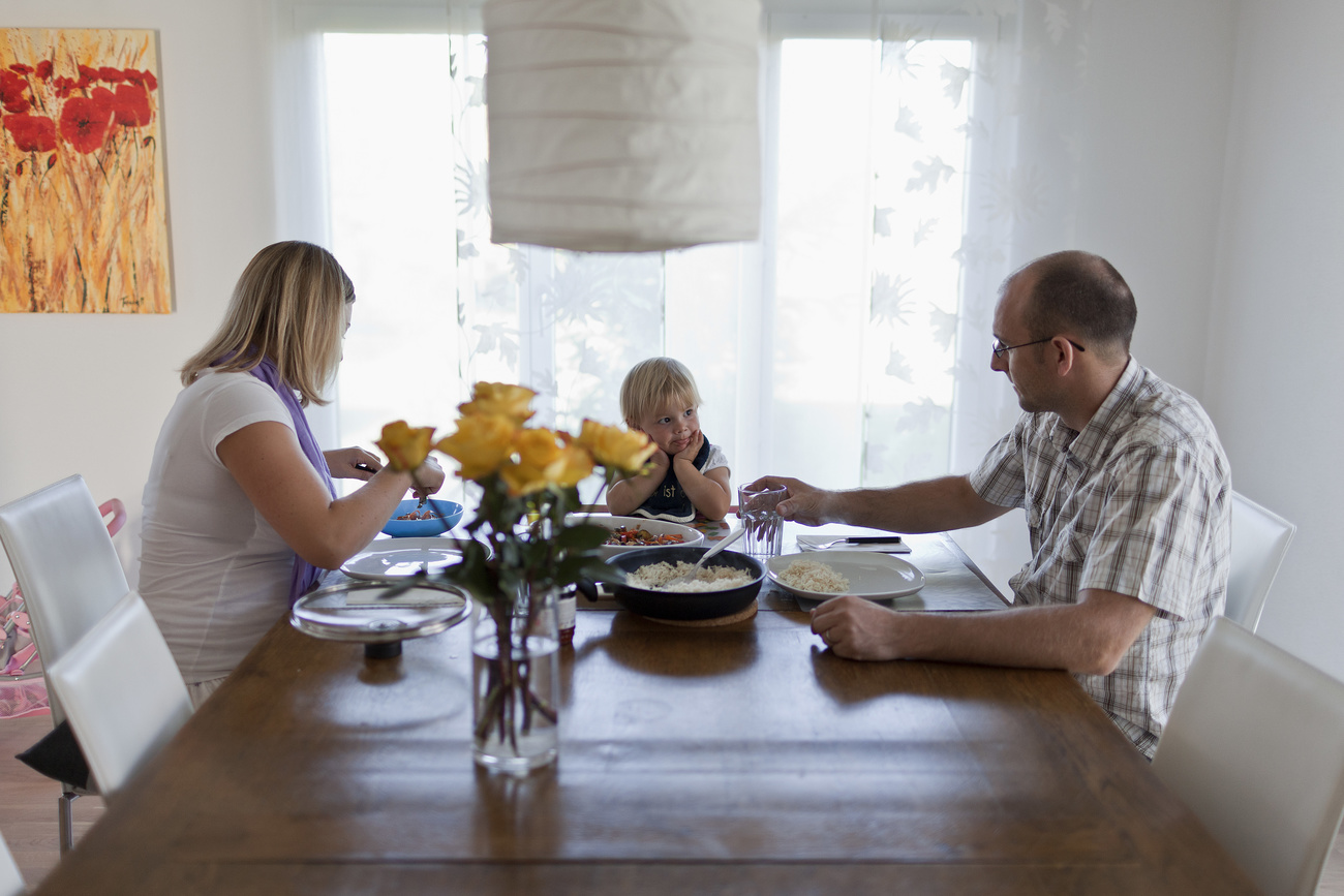 A família suíça janta em torno de uma mesa