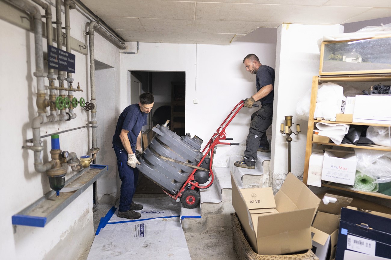Workers replace an oil boiler in a home.