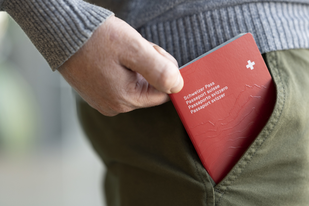 person pulling Swiss passport from pocket