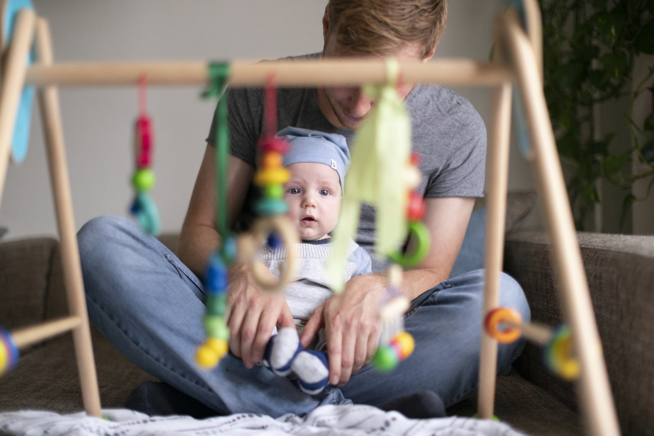 Un bimbo piccolo ta le braccia del padre.