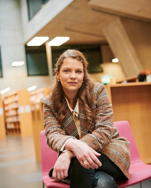 Rahel Freiburghaus sits in a library