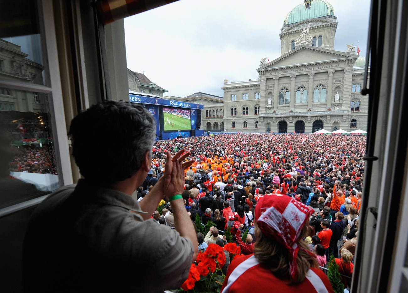 مئات الأشخاص يتابعون بثا لمقابلة كرة قدم على شاشة عملاقة