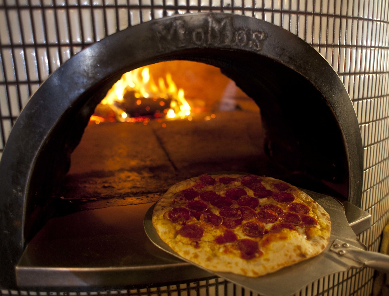 pizza estratta dal forno a legna