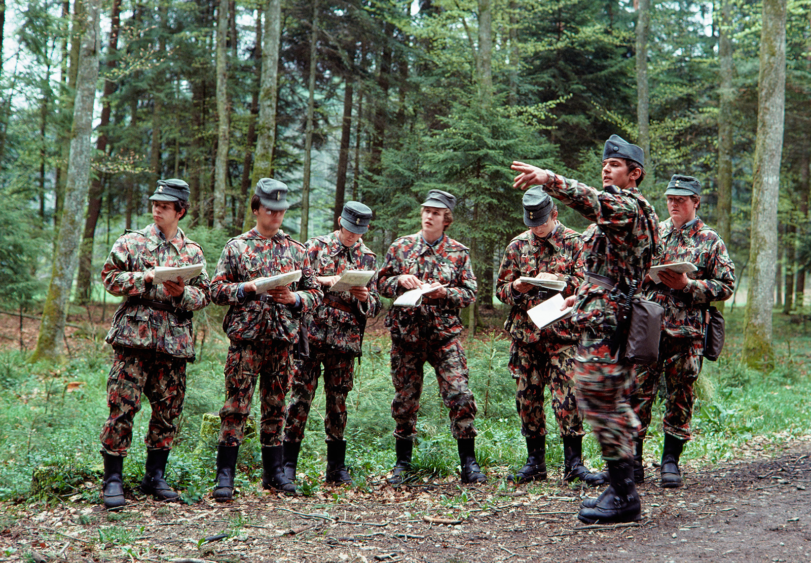 Groupe de soldats lisant des cartes dans une forêt