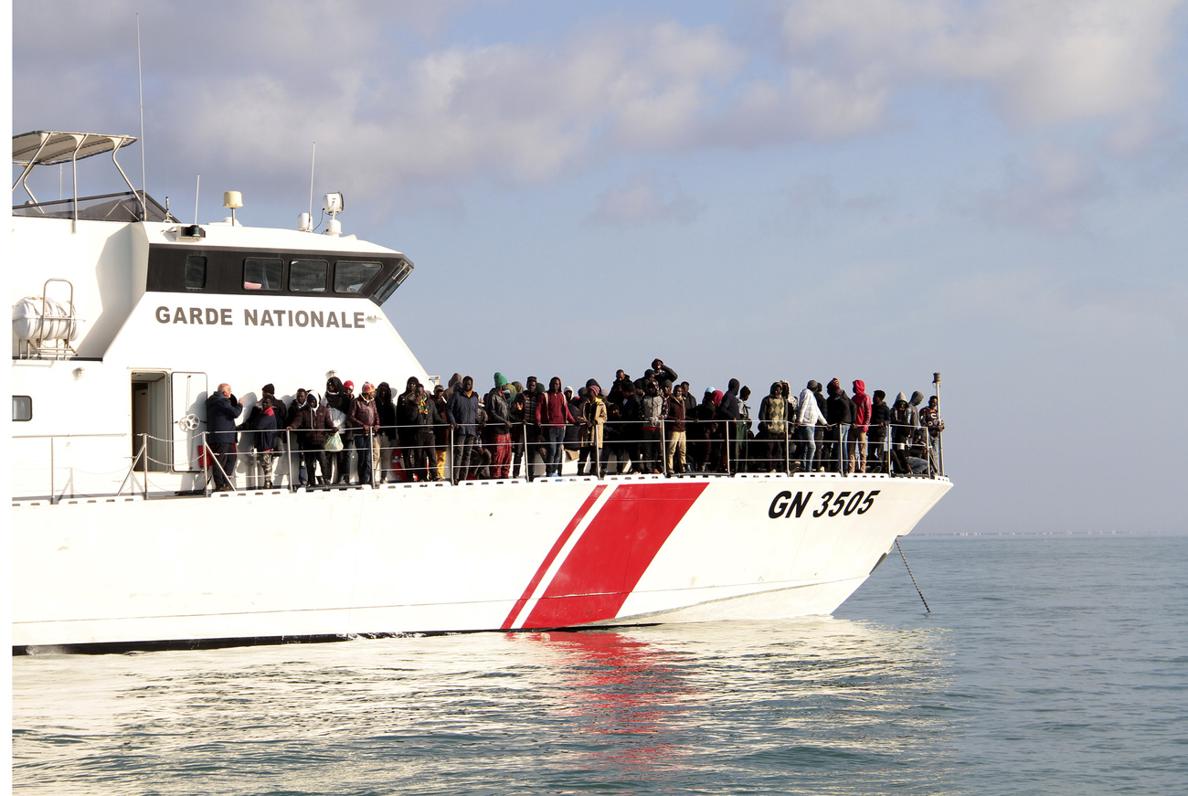 Des migrants noirs sur un bateau de garde-côtes
