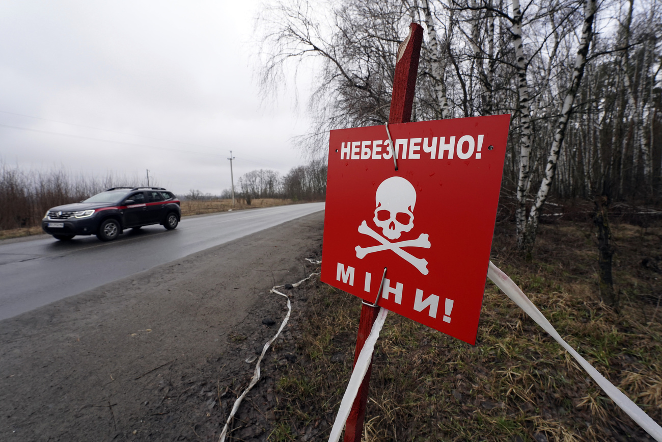 A car passes a mine warning sign in Ukraine