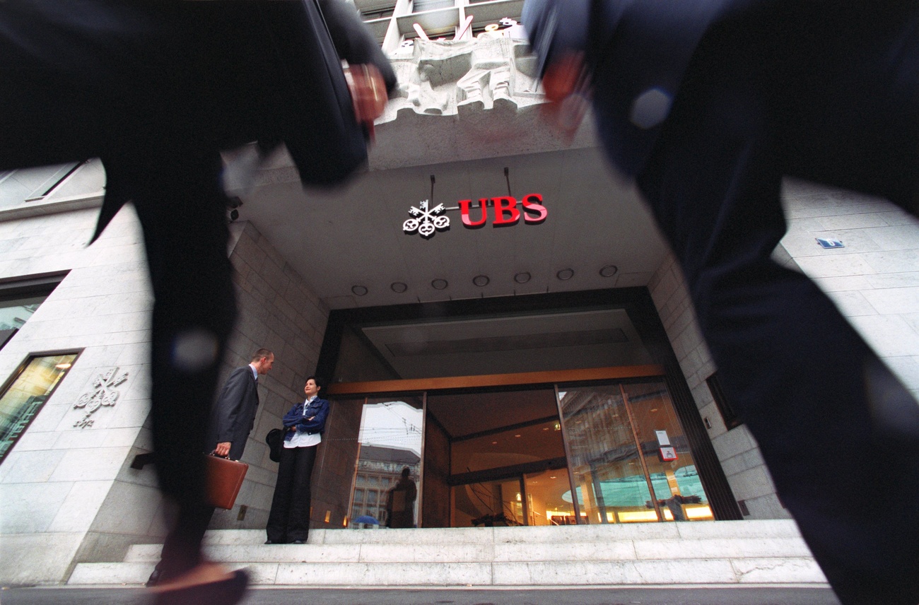 Picture of UBS bank with legs of two men walking towards the entrance
