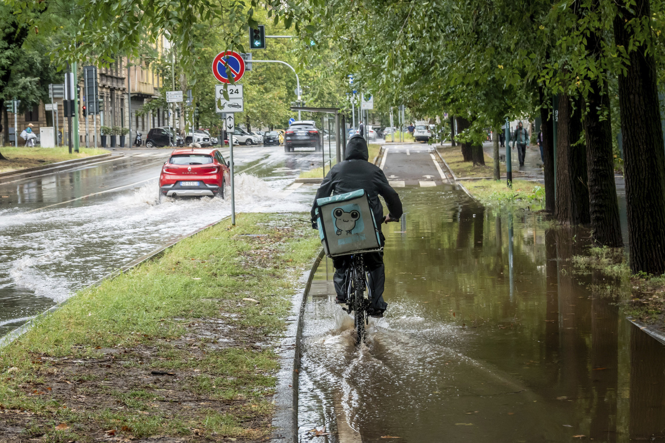 CIclista pedala su pista ciuclabile allagata a milano