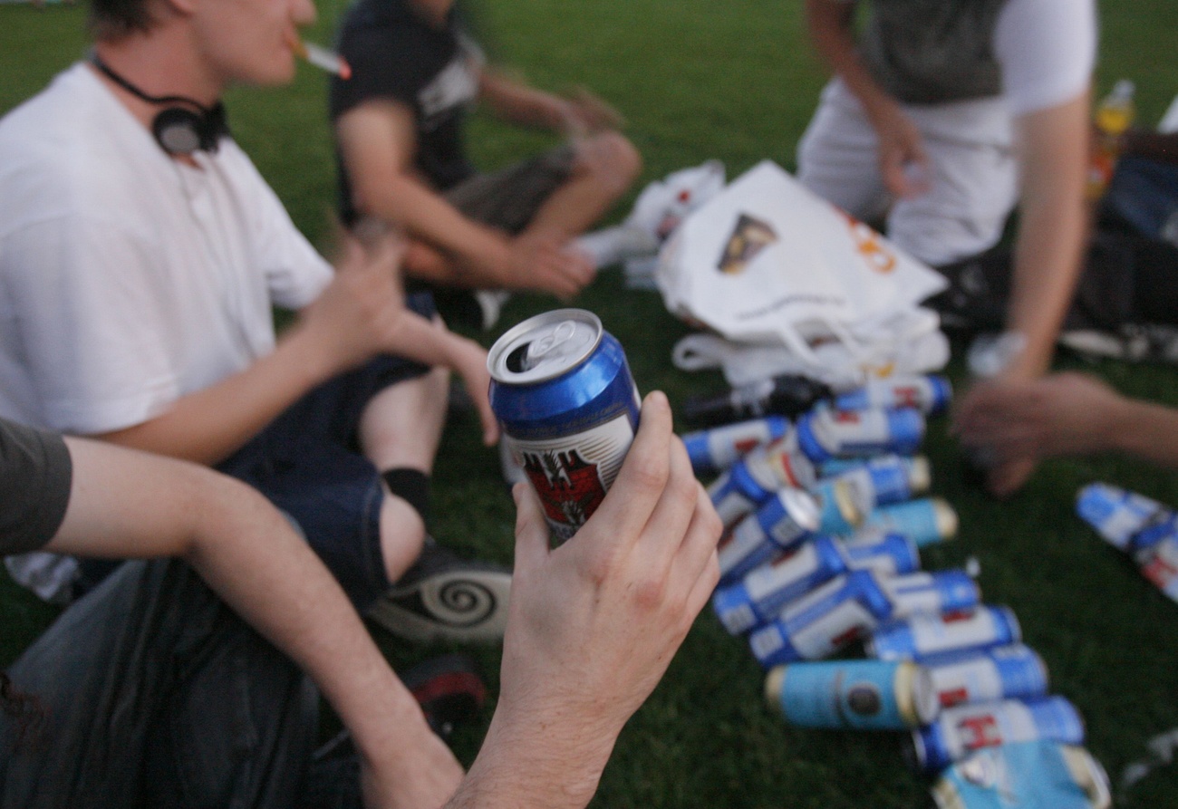 Young people drink beer in park