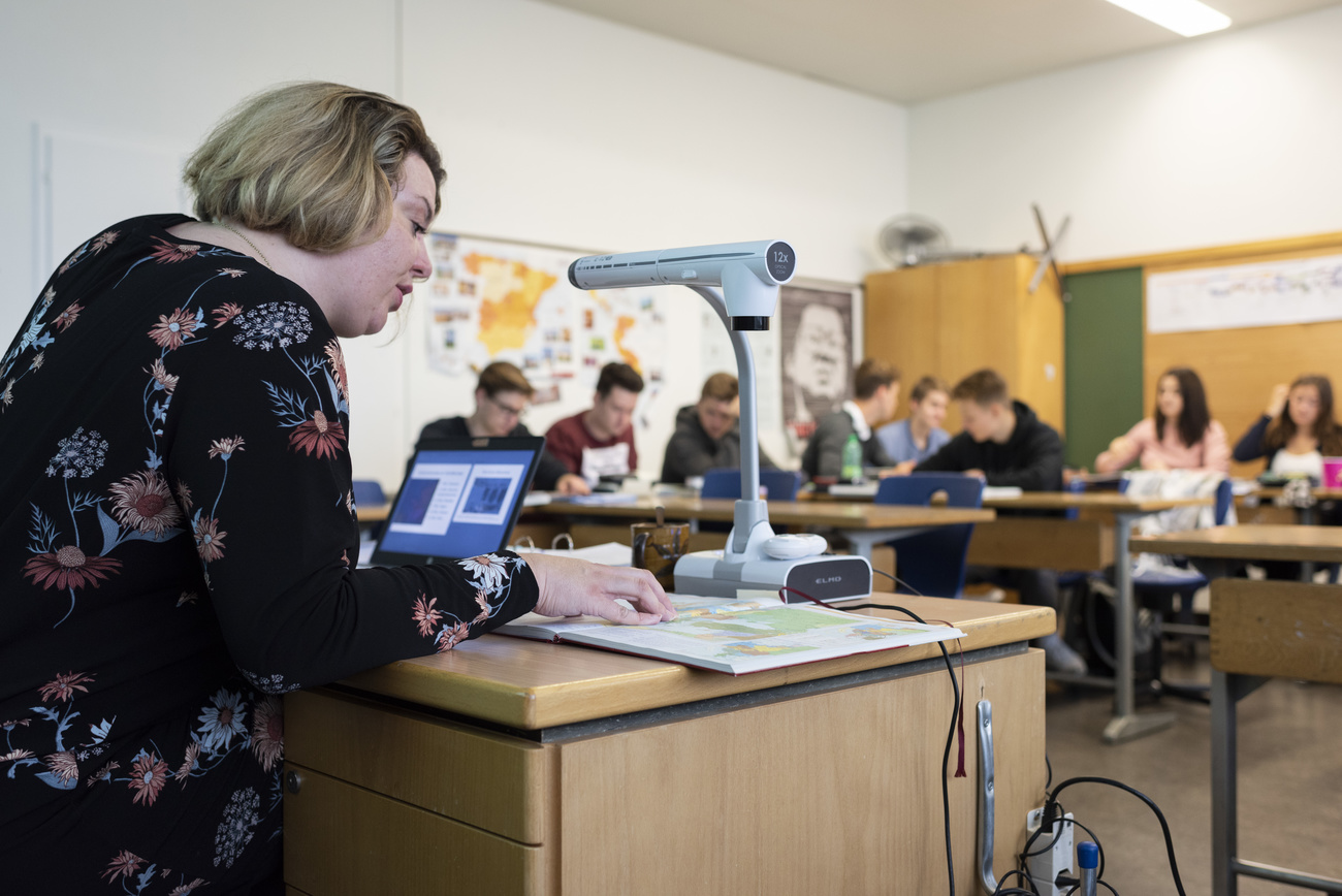 Imagen de un aula con profesores utilizando un ordenador portátil
