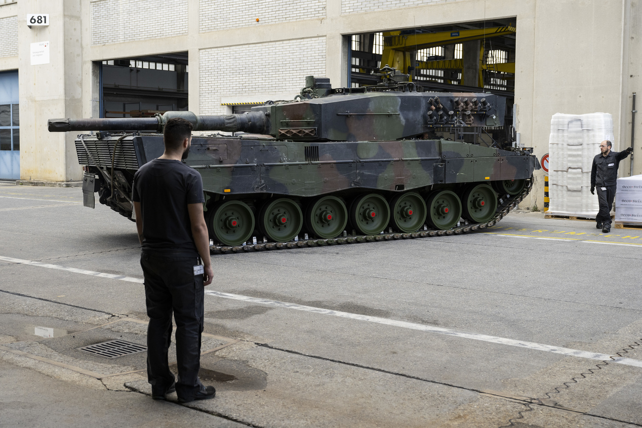 uomo in piedi osserva carro armato leopard 2