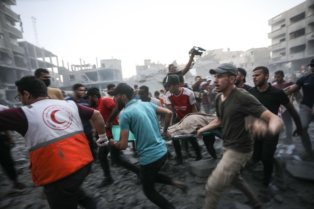 2023年10月15日星期日，以色列空襲加薩走廊南部拉法口岸的建築物後，巴勒斯坦人將一名受傷男子抬上擔架。聯合國報告稱，在以色列發動大規模空襲後，已有40多萬巴勒斯坦人逃離加薩北部，空襲造成2,000多名巴勒斯坦人喪生，其中一半是婦女和兒童。