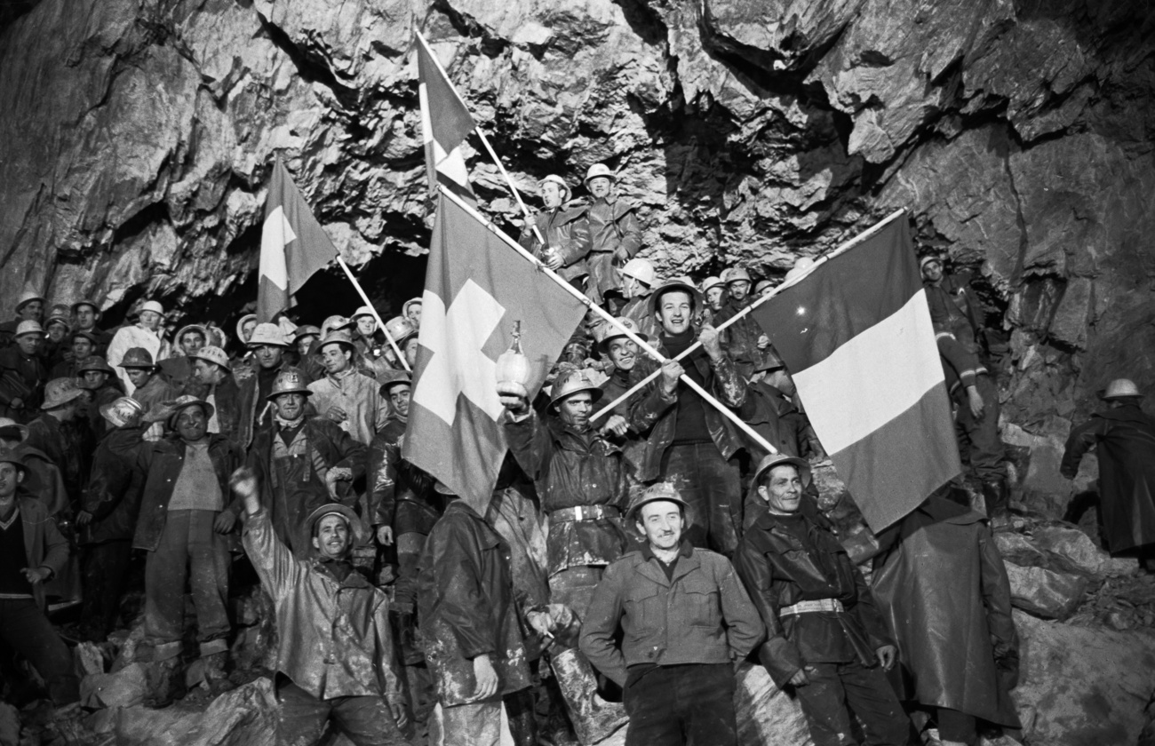 Des mineurs de deux pays avec leurs drapeaux dans un tunnel