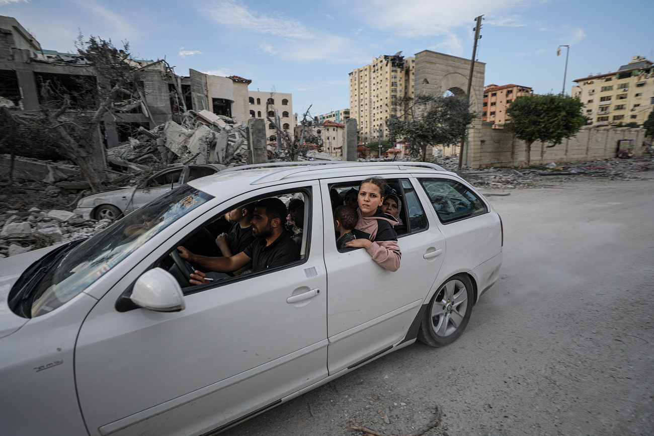 عائلة فلسطينية تهرب بعد غارة جوية إسرائيلية على حي تل الهوى