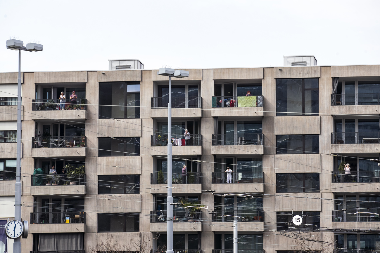 Persona affacciate sul balcone che applaudono verso gli operatori sanitari durante il Covid.