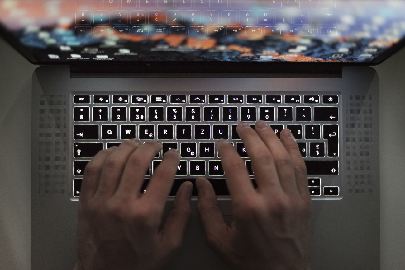 two hands typing on a keyboard