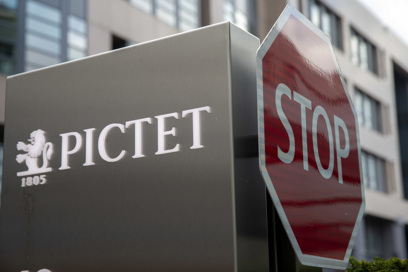Pictet bank sign next to a Stop traffic sign in Switzerland