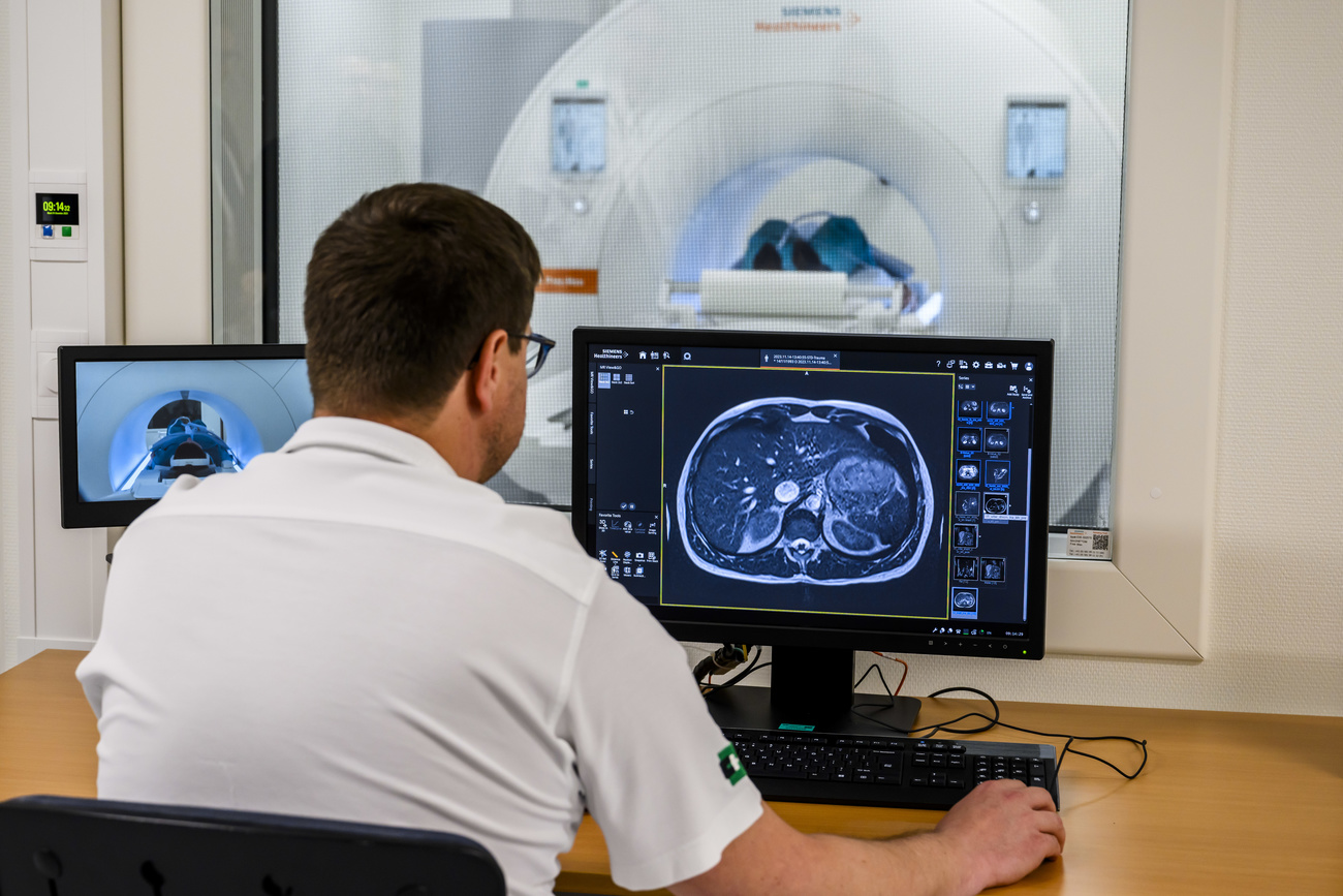 A medical radiology technician at CHUV checks his computer while using a new MRI device.