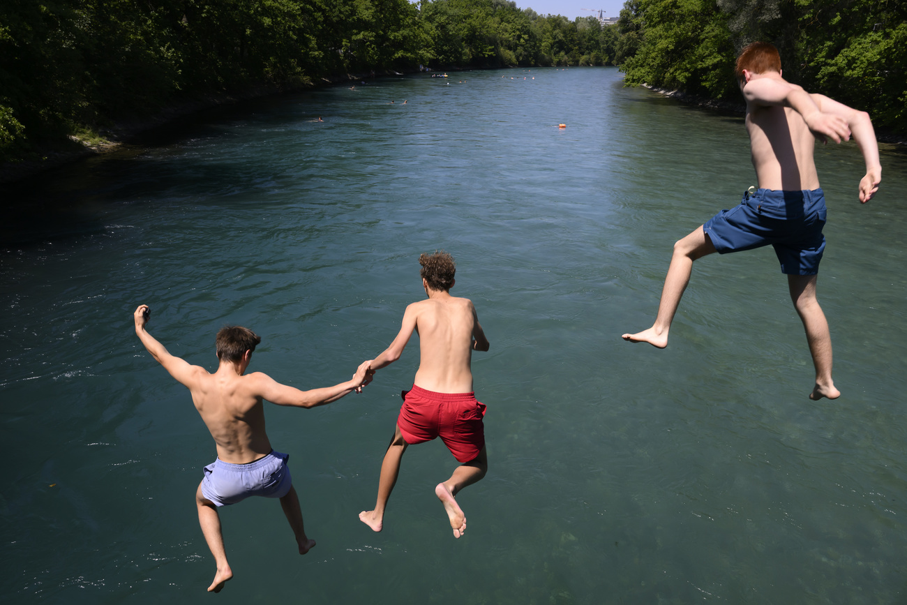 tre ragazzi in costume saltano in acqua