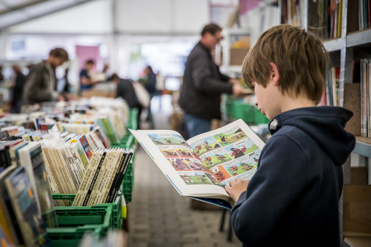 un jeune garçOn lit une BD