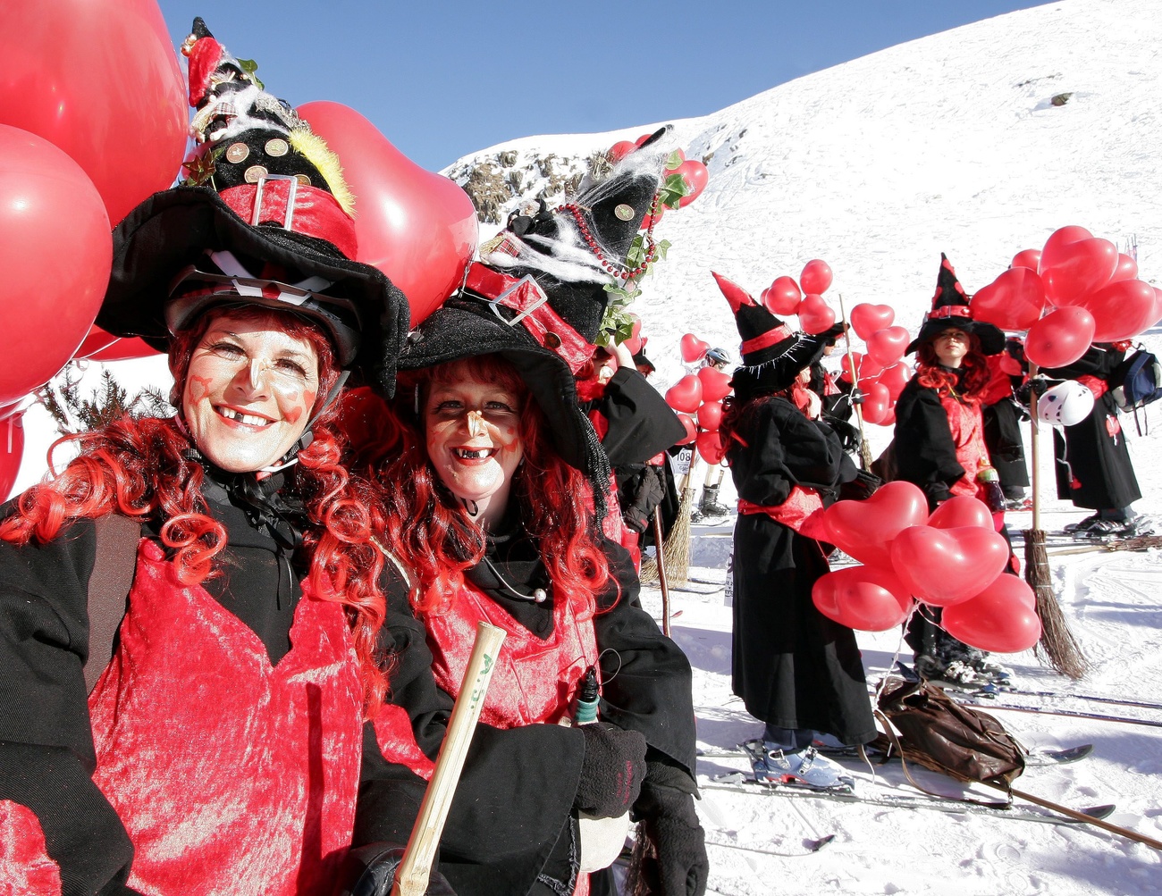 Skifahrerinnen, die als Hexen verkleidet sind.