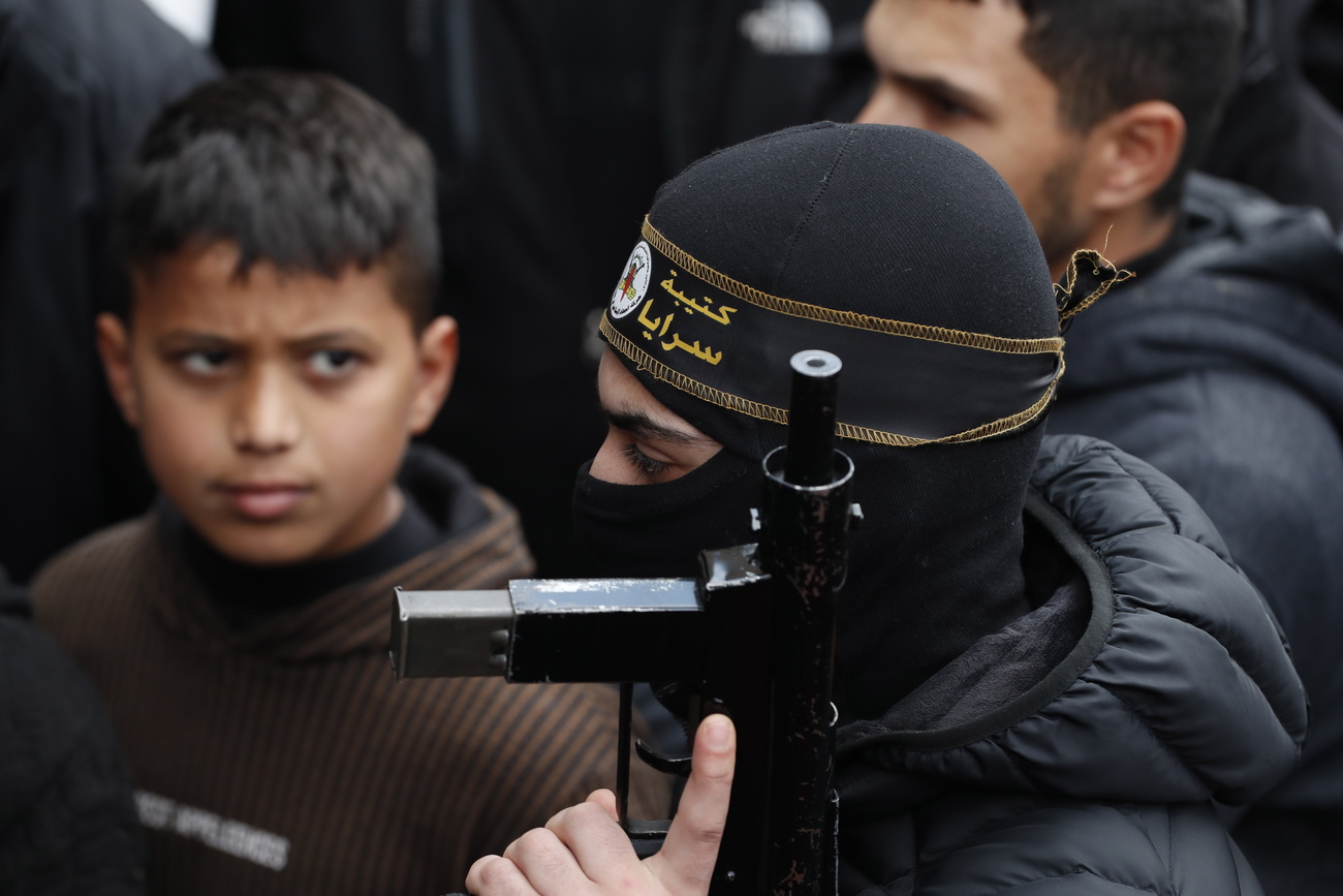 bambino guarda militante mascherato e armato
